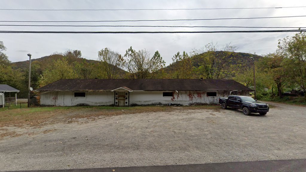 The 7348 Dupont Avenue commercial building — a low, single-story mid-century structure on Route 60 in Kanawha County, West Virginia, backed by Appalachian foothills.